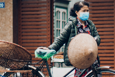 Women with mask holding a bike